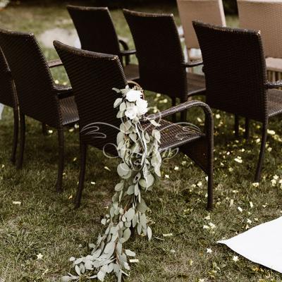 Dekoracyjne girlandy z żywych kwiatów przy krzesłach