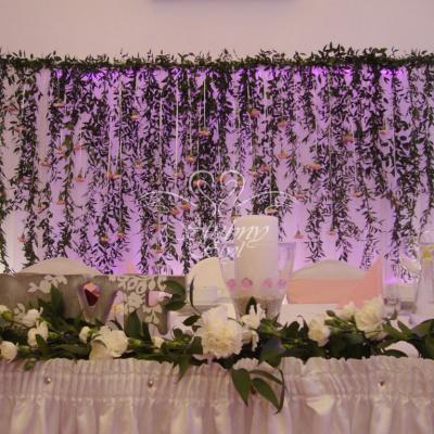Ścianka ślubna za Młodą Parą z zielonego ruskusa i różowych goździków 