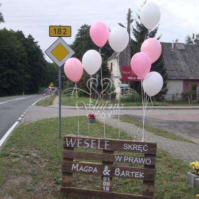 Drewniana paleta jako drogowskaz dla gości weselnych udekorowana balonami