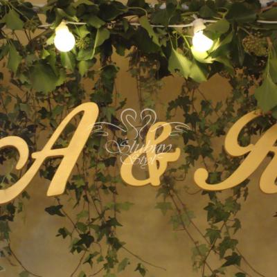 Złote drewniane literki na tle bluszczu