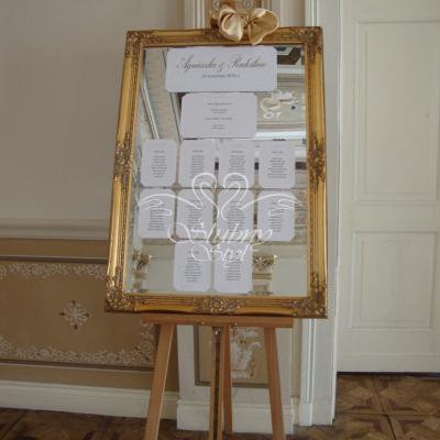 Eleganckie lustro w złotej ramie jako tablica z rozmieszczeniem gości