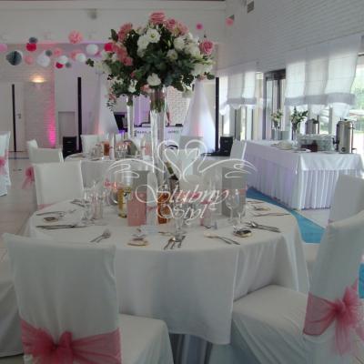 W tle sali na suficie biało różowo popielate pompony