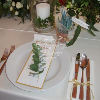 Zielona gałązka eukaliptusa w dekoracji stołu weselnego