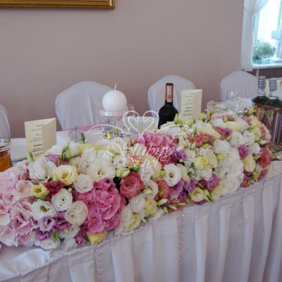 Kompozycja kwiatowa na stole reprezentacyjnym w odcieniach bieli i różu