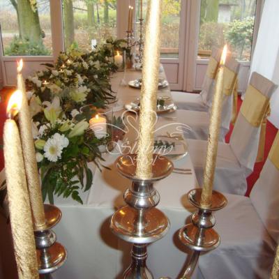Urokliwe złote świece w srebrnych wysokich kandelabrach