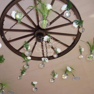 Dekoracja na suficie - drewniane koło z małymi bukiecikami w szklanych wazonikach