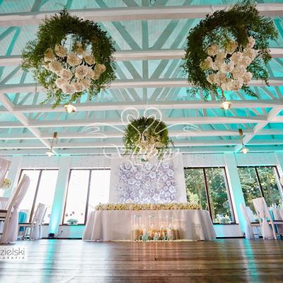 Koła wiklinowe udekorowane żywymi kwiatami zawieszone na suficie