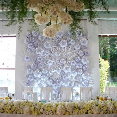 Przepiękna ścianka weselna z papierowych kwiatów za Parą Młodą