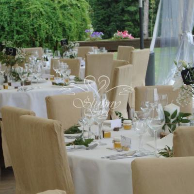 Świeczki na plastrach drewna przybrane dekoracyjną zielenią