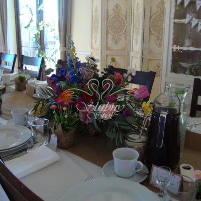 Kolorowy ogród kwiatowy w drewnianych brzozowych doniczkach na jutowych bieżnikach