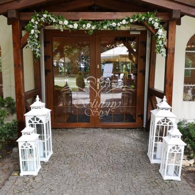 Dekoracja wejścia na salę weselną girlandą i lampionami