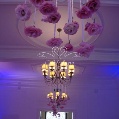 Główki różowej eustomy na wstążkach w dekoracji żyrandola