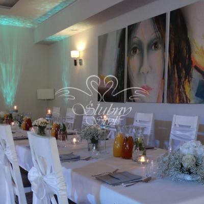 Białe materiałowe kokardy na krzesłach