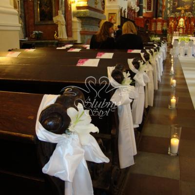 Urocze lilie przy ławkach w kościele