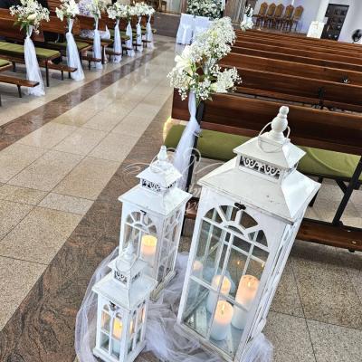 Białe drewniane lampiony w dekoracji kościoła na ślub