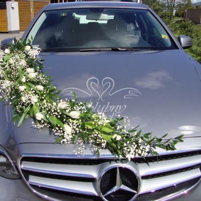 Dekoracje auta weselnego zieloną girlandą w połączeniu z gipsówką i białymi tulipanami